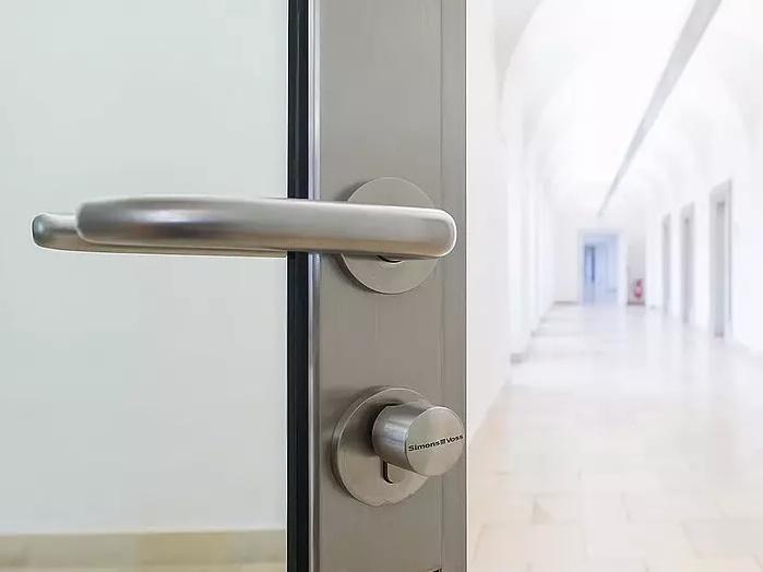 Türansicht mit modernem Beschlag, Blick auf einen hellen Flur mit langen Wänden und Bögen.