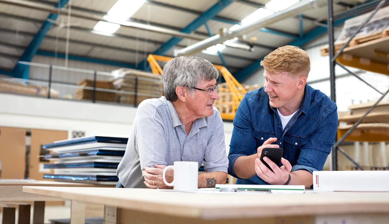 Beratschlagung in Werkstatt Zwei Männer beratschlagen sich in Werkstatt